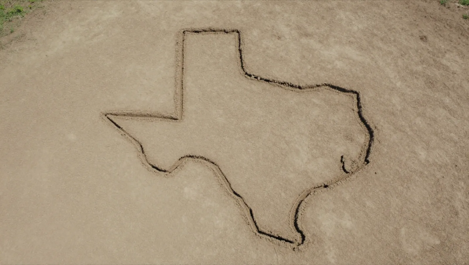 Hand-drawn Texas shape on sandy ground. No machinery used. Work: outline drawing — Daniel Dean Land Clearing, Southeast Texas