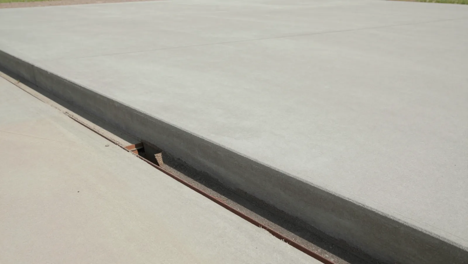 Concrete pavement terrain shows curb and joint construction work; no machinery visible — Daniel Dean Land Clearing, Southeast Texas