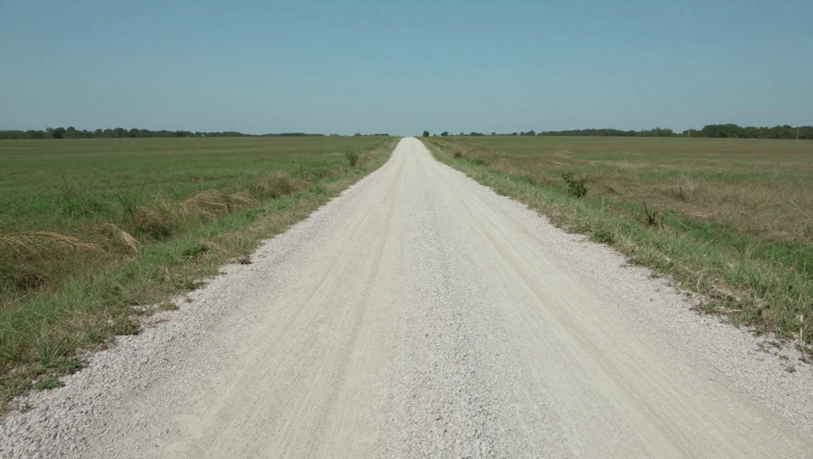 Foundation Builds in Conroe TX: Site Prep Tips by Daniel Dean Gravel road spans grassy terrain; no machinery visible, work done constructing the path — Daniel Dean Land Clearing, Southeast Texas