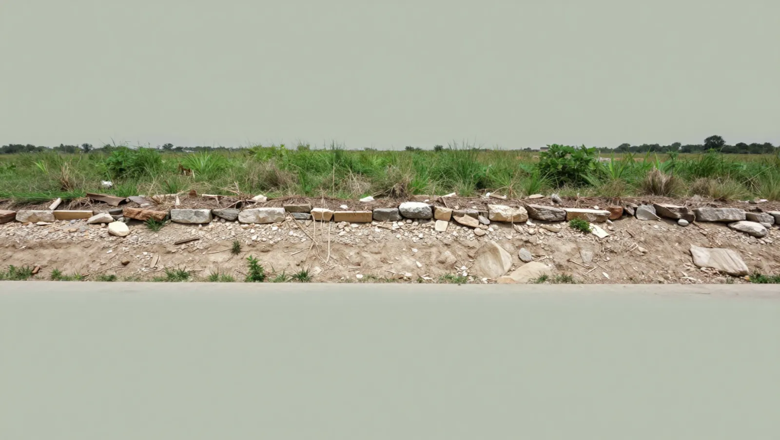 Erosion control in Katy, Texas — completed work Stone wall construction on sloped earthen terrain with grassy top; no machinery present — erosion control in Katy, Texas
