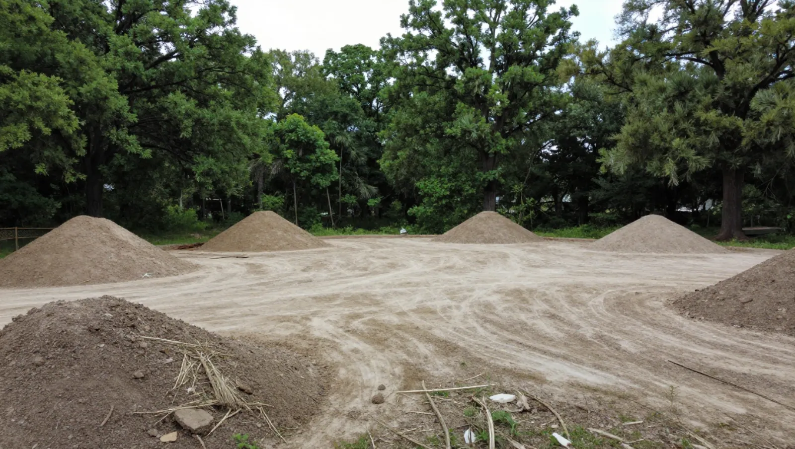 Land clearing in Humble, Texas — completed work Dirt piles on sandy ground; no machinery, earth-moving work for land preparation — land clearing in Humble, Texas