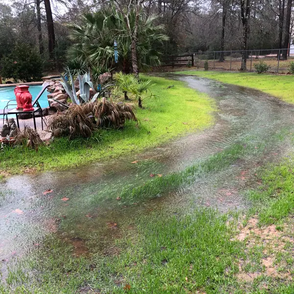 Swale redirecting water around the pool